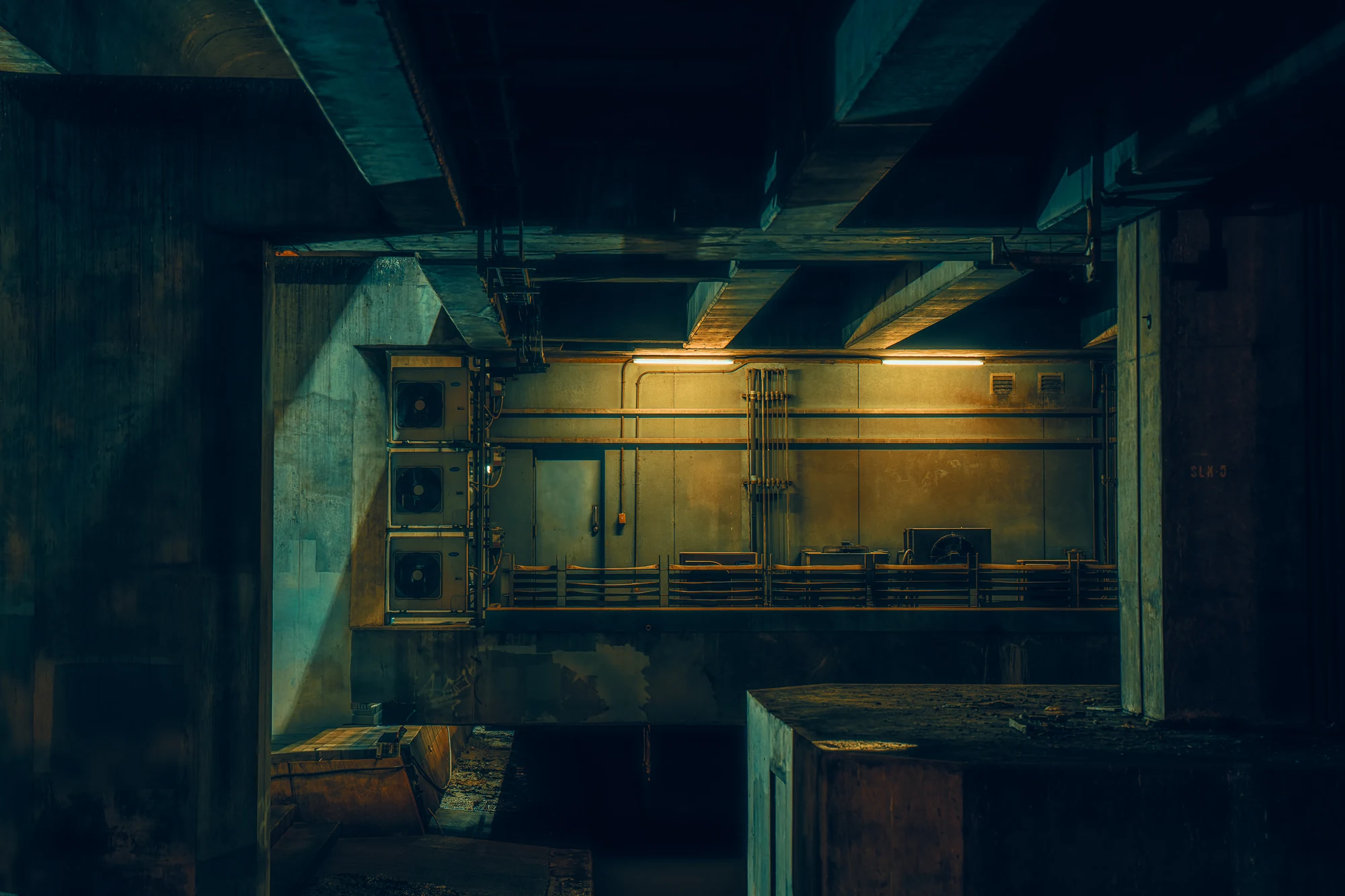Technical space under a concrete structure lit by two fluorescent tubes in Bangkok